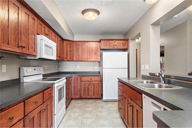 641 Lake St N, Big Lake, MN 55309 - kitchen featuring white appliances, a textured ceiling, light flooring, brown cabinets, and dark countertops