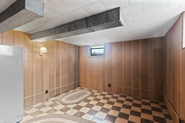 6112 Kyle Ave N, Brooklyn Center, MN 55429 - basement with freestanding refrigerator, wood walls, and tile patterned floors