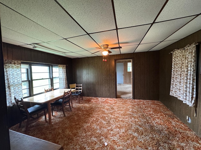 92354 Lake 12 Rd, Windemere Twp, MN 55783 - carpeted dining area with wood walls, a drop ceiling, and a ceiling fan