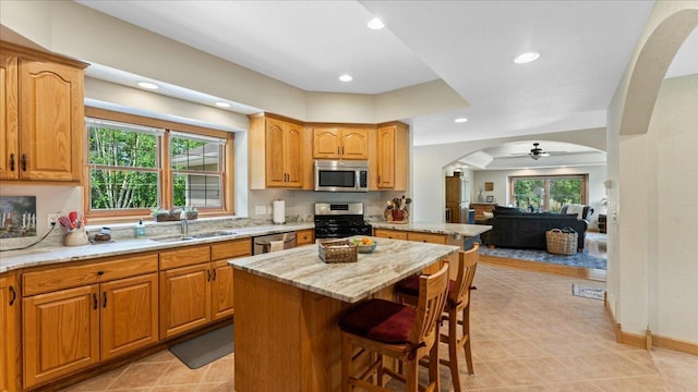 1764 State 84 SW, Pine River, MN 56474 - kitchen with arched walkways, appliances with stainless steel finishes, ceiling fan, a kitchen bar, and light stone countertops