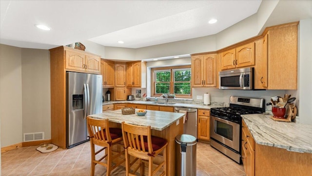 1764 State 84 SW, Pine River, MN 56474 - kitchen featuring appliances with stainless steel finishes, a kitchen bar, light tile patterned flooring, a center island, and recessed lighting