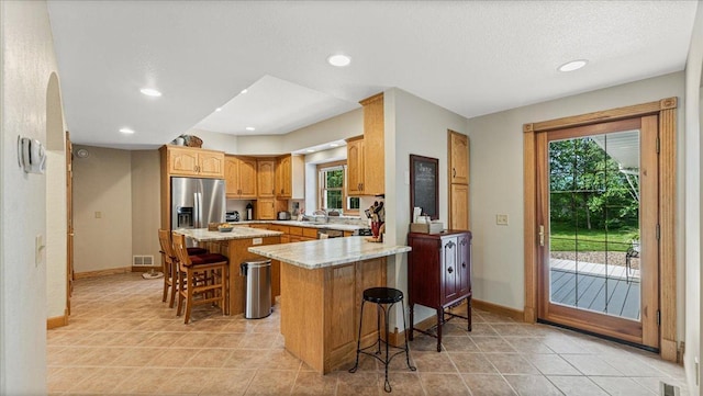 1764 State 84 SW, Pine River, MN 56474 - kitchen featuring a breakfast bar area, a peninsula, a kitchen island, recessed lighting, and stainless steel fridge