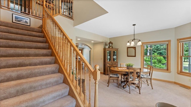 1764 State 84 SW, Pine River, MN 56474 - dining space with light colored carpet, arched walkways, stairway, a chandelier, and recessed lighting