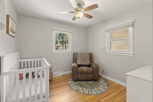 755 Keokuk Ln, Mendota Heights, MN 55120 - bedroom with wood finished floors, a crib, and a ceiling fan