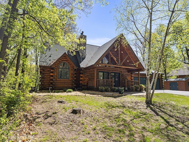 25533 Heritage Ln, Wyoming, MN 55092 - cabin with log siding, concrete driveway, a chimney, a shingled roof, and an attached garage