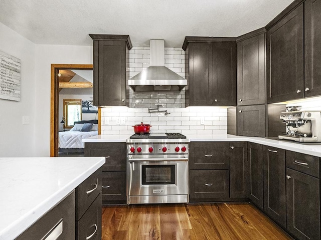 25533 Heritage Ln, Wyoming, MN 55092 - kitchen featuring premium stove, wall chimney exhaust hood, dark wood-type flooring, tasteful backsplash, and light countertops
