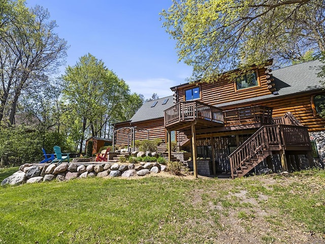 25533 Heritage Ln, Wyoming, MN 55092 - back of property with stairs, log exterior, a deck, a fire pit, and a lawn