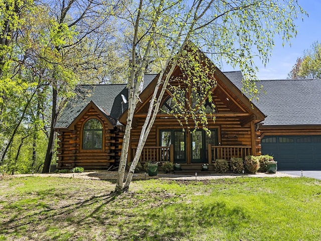 25533 Heritage Ln, Wyoming, MN 55092 - log-style house featuring a shingled roof, covered porch, an attached garage, log exterior, and a front yard