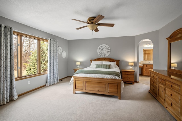 8051 Enclave Bay, Woodbury, MN 55125 - bedroom featuring light colored carpet, arched walkways, ensuite bathroom, and a ceiling fan
