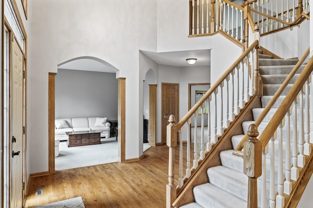 8051 Enclave Bay, Woodbury, MN 55125 - entryway with arched walkways, a towering ceiling, wood finished floors, and stairway