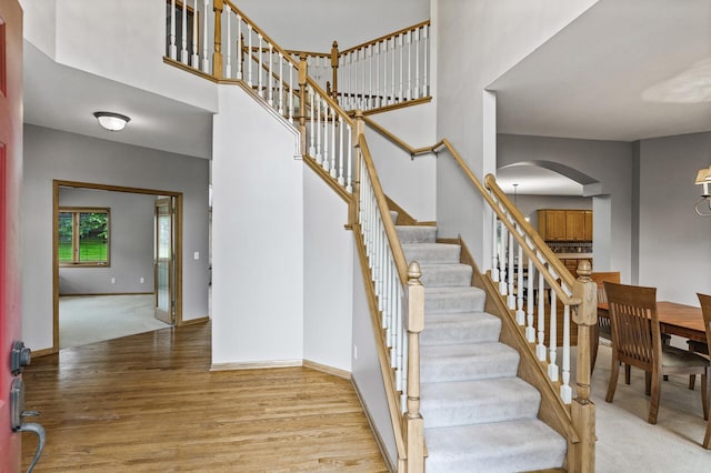 8051 Enclave Bay, Woodbury, MN 55125 - stairway featuring arched walkways, a high ceiling, and wood finished floors