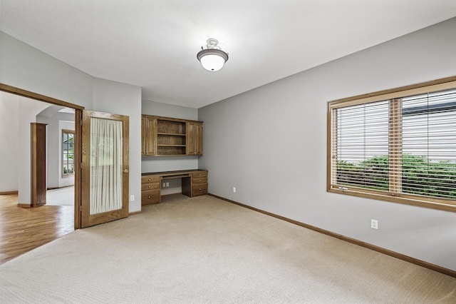 8051 Enclave Bay, Woodbury, MN 55125 - unfurnished living room with built in study area, light colored carpet, and arched walkways