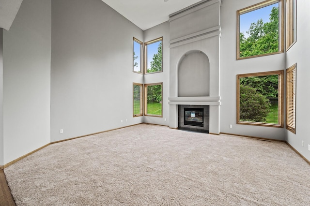 8051 Enclave Bay, Woodbury, MN 55125 - unfurnished living room with a high ceiling, carpet flooring, and a tile fireplace