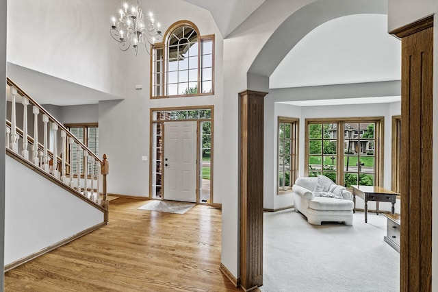 8051 Enclave Bay, Woodbury, MN 55125 - foyer entrance featuring wood finished floors, a chandelier, a towering ceiling, stairway, and decorative columns