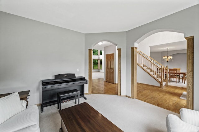 8051 Enclave Bay, Woodbury, MN 55125 - living area featuring arched walkways, a chandelier, light carpet, stairway, and decorative columns