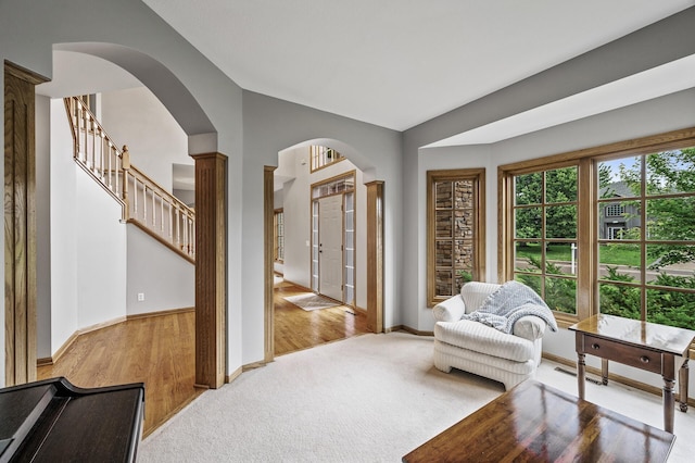 8051 Enclave Bay, Woodbury, MN 55125 - living area with arched walkways, light carpet, light wood-type flooring, and vaulted ceiling