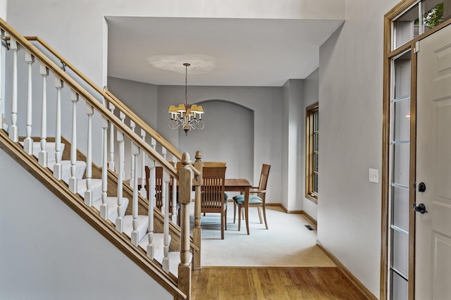 8051 Enclave Bay, Woodbury, MN 55125 - entryway featuring wood finished floors, a chandelier, stairway, and arched walkways