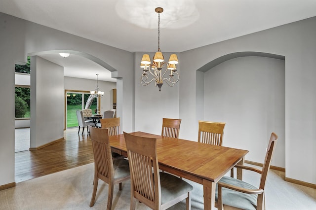 8051 Enclave Bay, Woodbury, MN 55125 - dining room featuring a chandelier, arched walkways, and light carpet