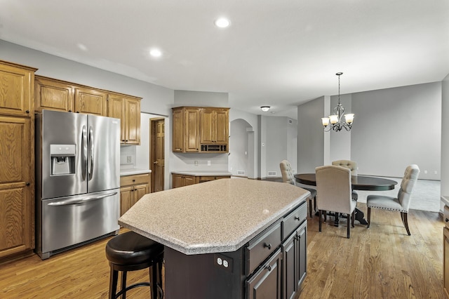 8051 Enclave Bay, Woodbury, MN 55125 - kitchen with stainless steel fridge, arched walkways, a center island, light wood-style flooring, and a chandelier