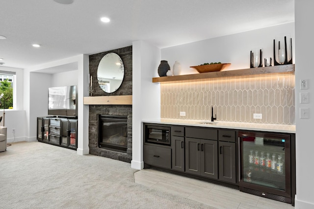 16942 47th Pl N, Plymouth, MN 55446 - indoor wet bar featuring beverage cooler, built in microwave, a stone fireplace, decorative backsplash, and recessed lighting