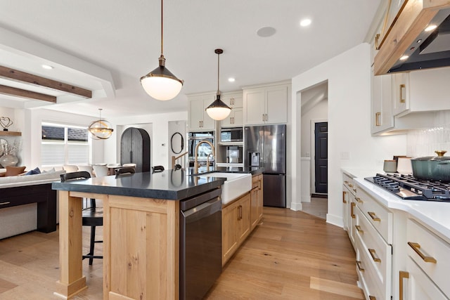 16942 47th Pl N, Plymouth, MN 55446 - kitchen featuring appliances with stainless steel finishes, extractor fan, a breakfast bar, light wood-style flooring, and decorative backsplash