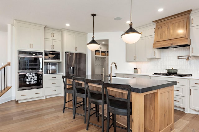 16942 47th Pl N, Plymouth, MN 55446 - kitchen featuring stainless steel appliances, light wood-style floors, tasteful backsplash, dark countertops, and a kitchen breakfast bar