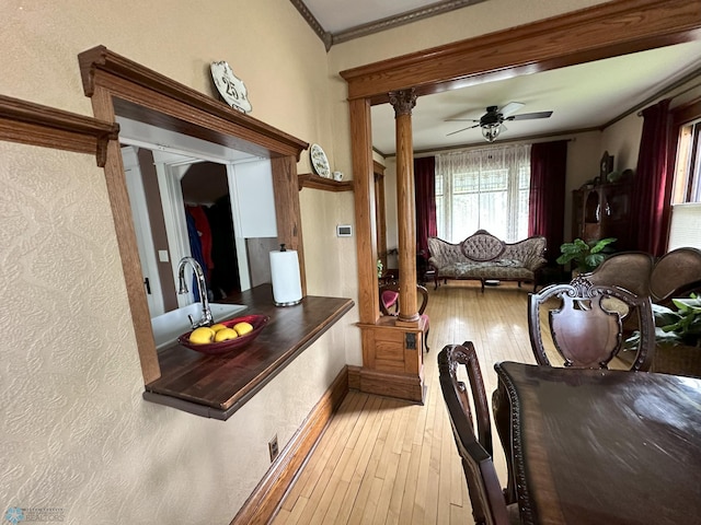 619 University Dr S, Fargo, ND 58103 - dining space featuring decorative columns, crown molding, light wood-style floors, a ceiling fan, and a textured wall
