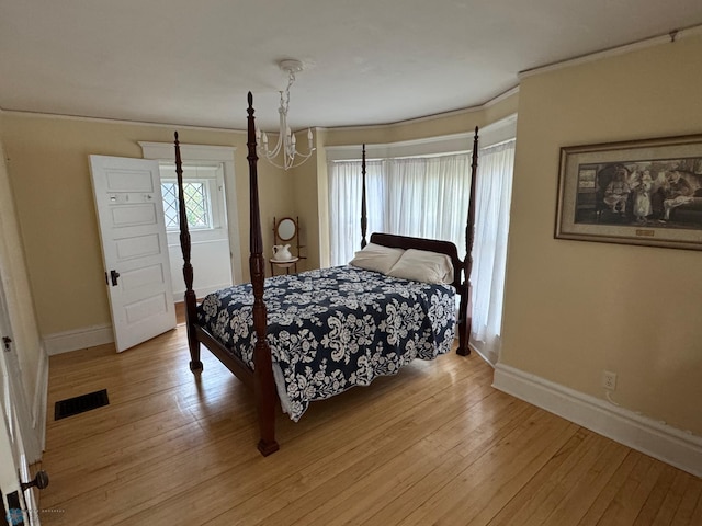619 University Dr S, Fargo, ND 58103 - bedroom featuring light wood finished floors, crown molding, and a chandelier