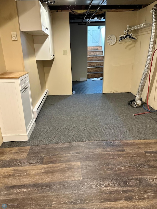 619 University Dr S, Fargo, ND 58103 - below grade area featuring a baseboard radiator, stairway, and dark wood-style flooring