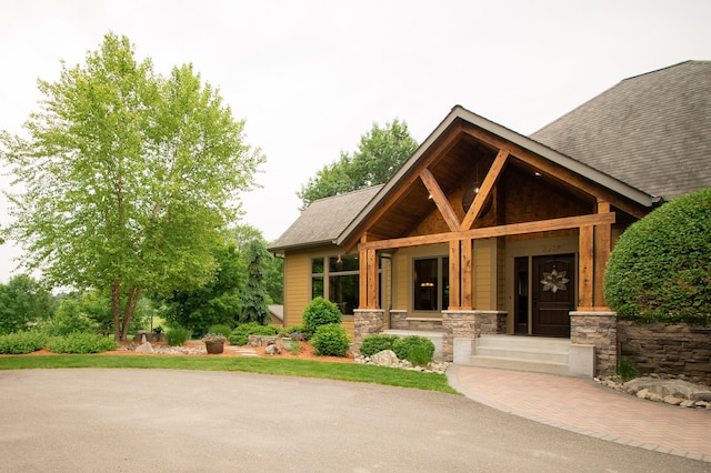 8271 Barton Ave NW, Buffalo, MN 55313 - view of front of house featuring stone siding, a shingled roof, and covered porch