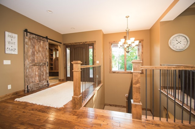 8271 Barton Ave NW, Buffalo, MN 55313 - foyer entrance featuring a chandelier, a barn door, and hardwood / wood-style flooring