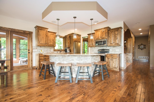 8271 Barton Ave NW, Buffalo, MN 55313 - kitchen featuring appliances with stainless steel finishes, dark wood-type flooring, brown cabinetry, and recessed lighting