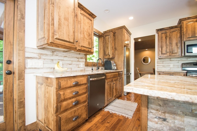 8271 Barton Ave NW, Buffalo, MN 55313 - kitchen with appliances with stainless steel finishes, light stone countertops, backsplash, dark wood-style flooring, and brown cabinets