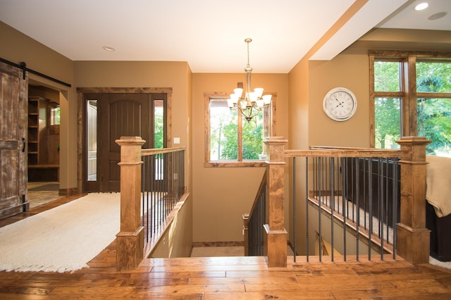 8271 Barton Ave NW, Buffalo, MN 55313 - staircase featuring a chandelier, wood finished floors, and a barn door