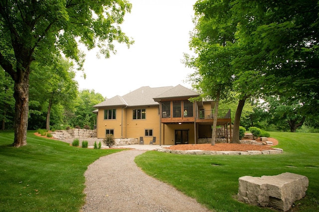 8271 Barton Ave NW, Buffalo, MN 55313 - back of property featuring a sunroom, a lawn, a deck, and driveway