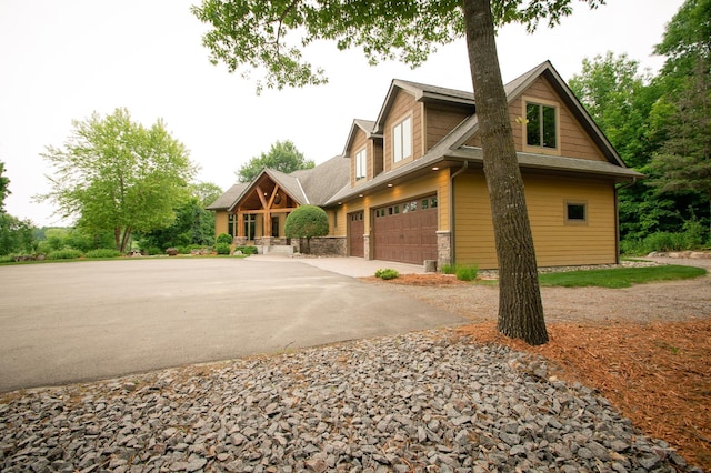 8271 Barton Ave NW, Buffalo, MN 55313 - view of front of home featuring asphalt driveway, an attached garage, stone siding, and a shingled roof