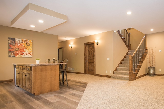 8271 Barton Ave NW, Buffalo, MN 55313 - kitchen featuring a breakfast bar area, recessed lighting, light wood-style flooring, a kitchen island, and brown cabinetry