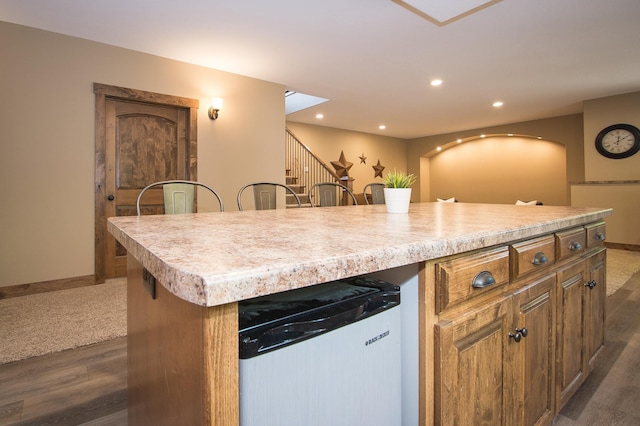 8271 Barton Ave NW, Buffalo, MN 55313 - kitchen featuring dark wood-style flooring, light countertops, a center island, brown cabinetry, and recessed lighting
