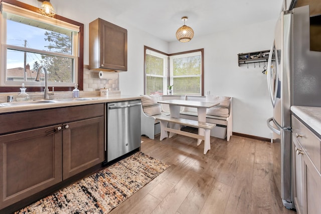 632 Quince St, Duluth, MN 55811 - kitchen with stainless steel appliances, light wood-style floors, light countertops, and backsplash