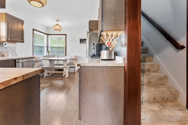 632 Quince St, Duluth, MN 55811 - kitchen with stainless steel dishwasher, light wood-type flooring, wood counters, tasteful backsplash, and dark brown cabinetry