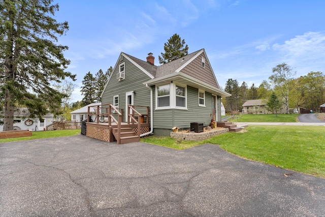 632 Quince St, Duluth, MN 55811 - view of home's exterior with a chimney, a wooden deck, a yard, and a shingled roof