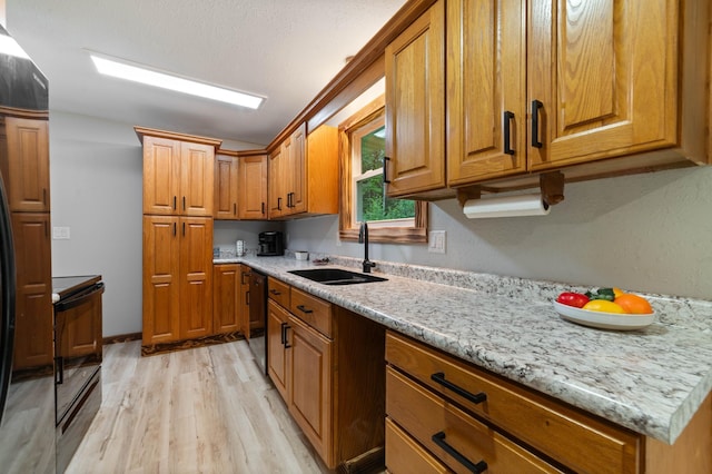 185 Olson Rd, Thomson Twp, MN 55733 - kitchen featuring black appliances, brown cabinets, light wood-type flooring, and light stone counters