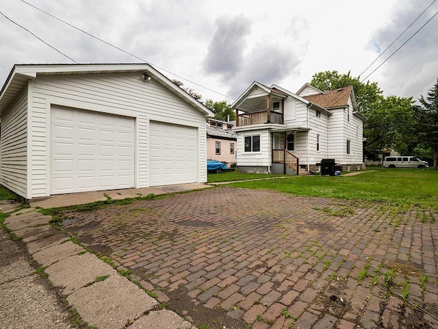4021 Colfax Ave N, Minneapolis, MN 55412 - view of front of house with an outdoor structure, a balcony, a detached garage, and a front lawn