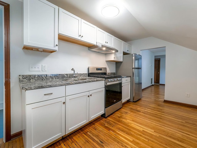 4021 Colfax Ave N, Minneapolis, MN 55412 - kitchen featuring appliances with stainless steel finishes, under cabinet range hood, light wood finished floors, lofted ceiling, and white cabinets