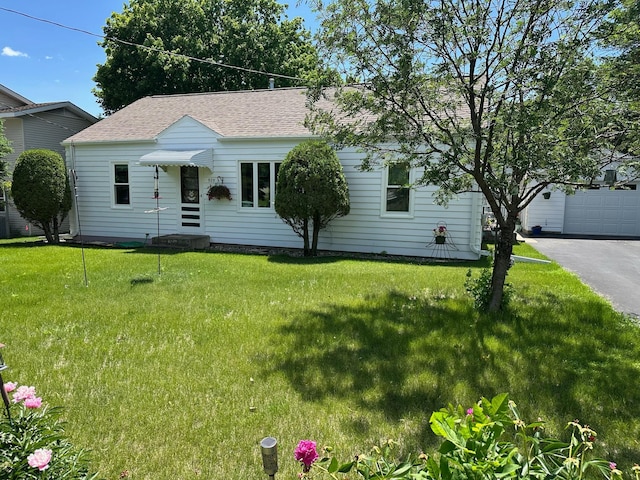 925 Willow St W, Detroit Lakes, MN 56501 - view of front of house with a front yard, a shingled roof, a garage, and asphalt driveway