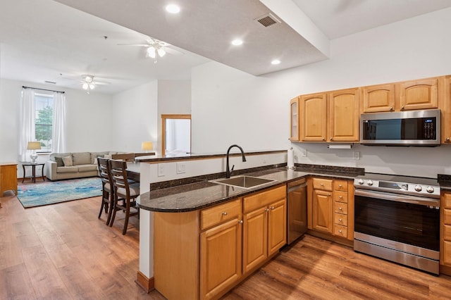 30 Main St S Unit 5E, Pine City, MN 55063 - kitchen featuring stainless steel appliances, a peninsula, ceiling fan, dark stone counters, and wood finished floors