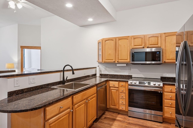 30 Main St S Unit 5E, Pine City, MN 55063 - kitchen with appliances with stainless steel finishes, a peninsula, light wood finished floors, ceiling fan, and dark stone countertops