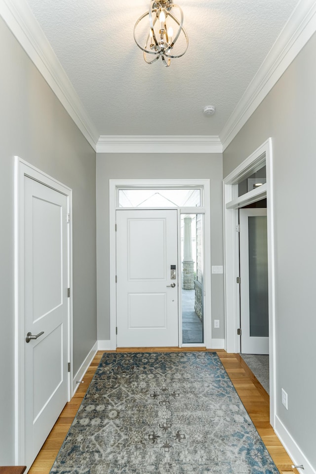1062 Fox Hill Ln SW, Rochester, MN 55902 - foyer entrance featuring ornamental molding, a chandelier, light wood-type flooring, and a textured ceiling
