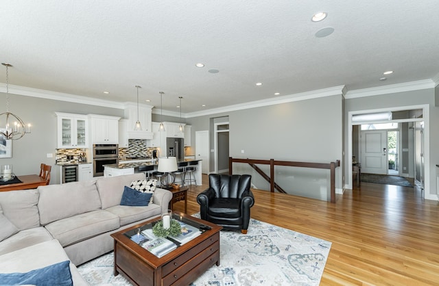 1062 Fox Hill Ln SW, Rochester, MN 55902 - living area with a chandelier, light wood-style flooring, recessed lighting, wine cooler, and a textured ceiling