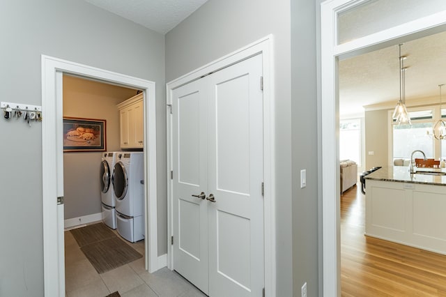 1062 Fox Hill Ln SW, Rochester, MN 55902 - washroom featuring cabinet space, independent washer and dryer, and light wood-style flooring